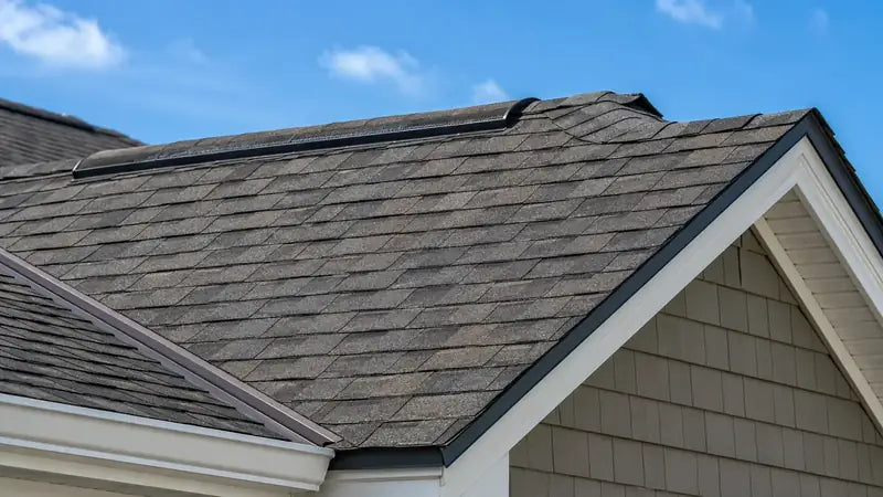 Close-up of architectural shingles, a ridge vent and the roof edge
